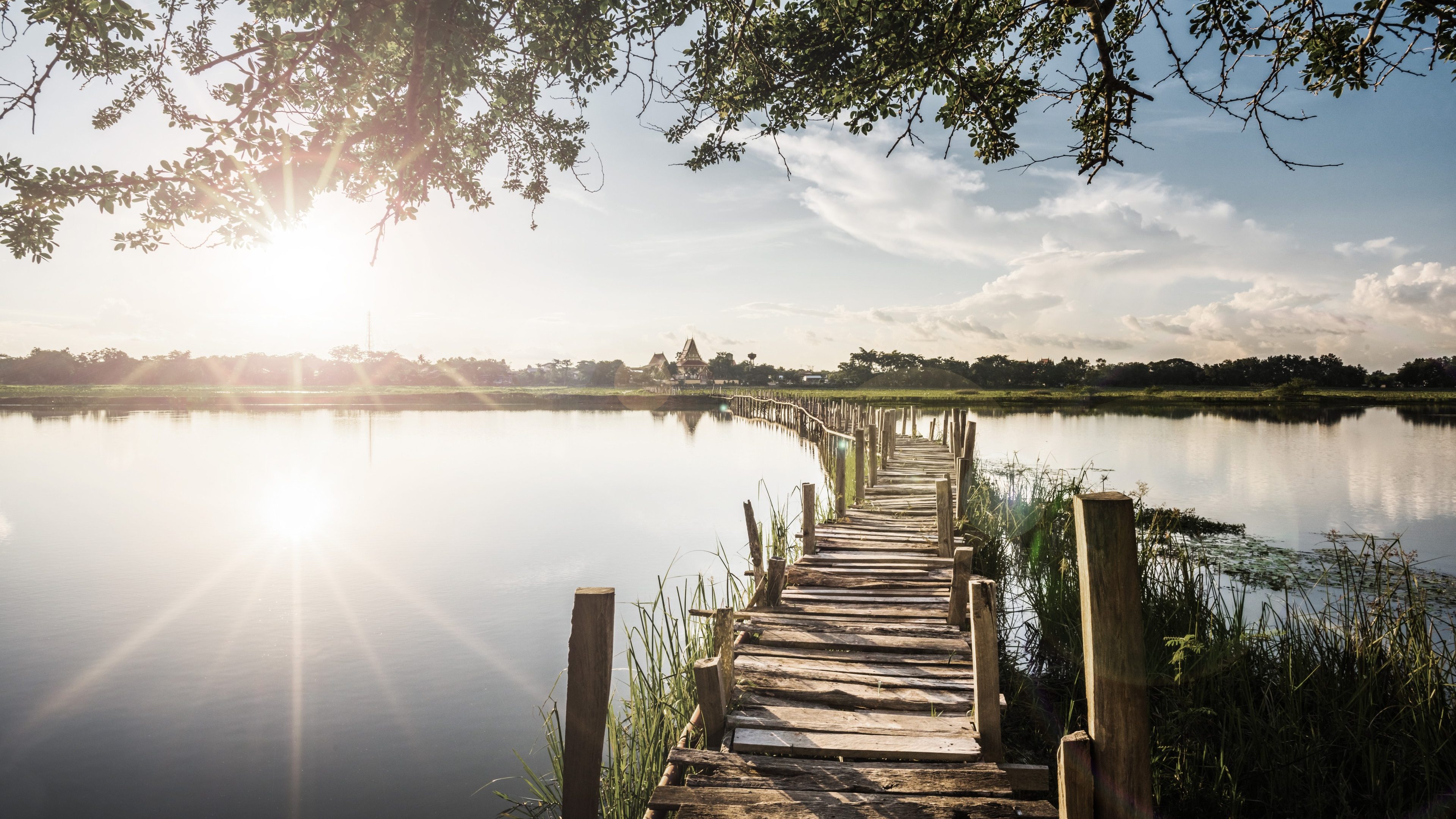 Long wooden bridge across the lake on sunset background at Kae Dam District, Maha Sarakham Province, Thailand