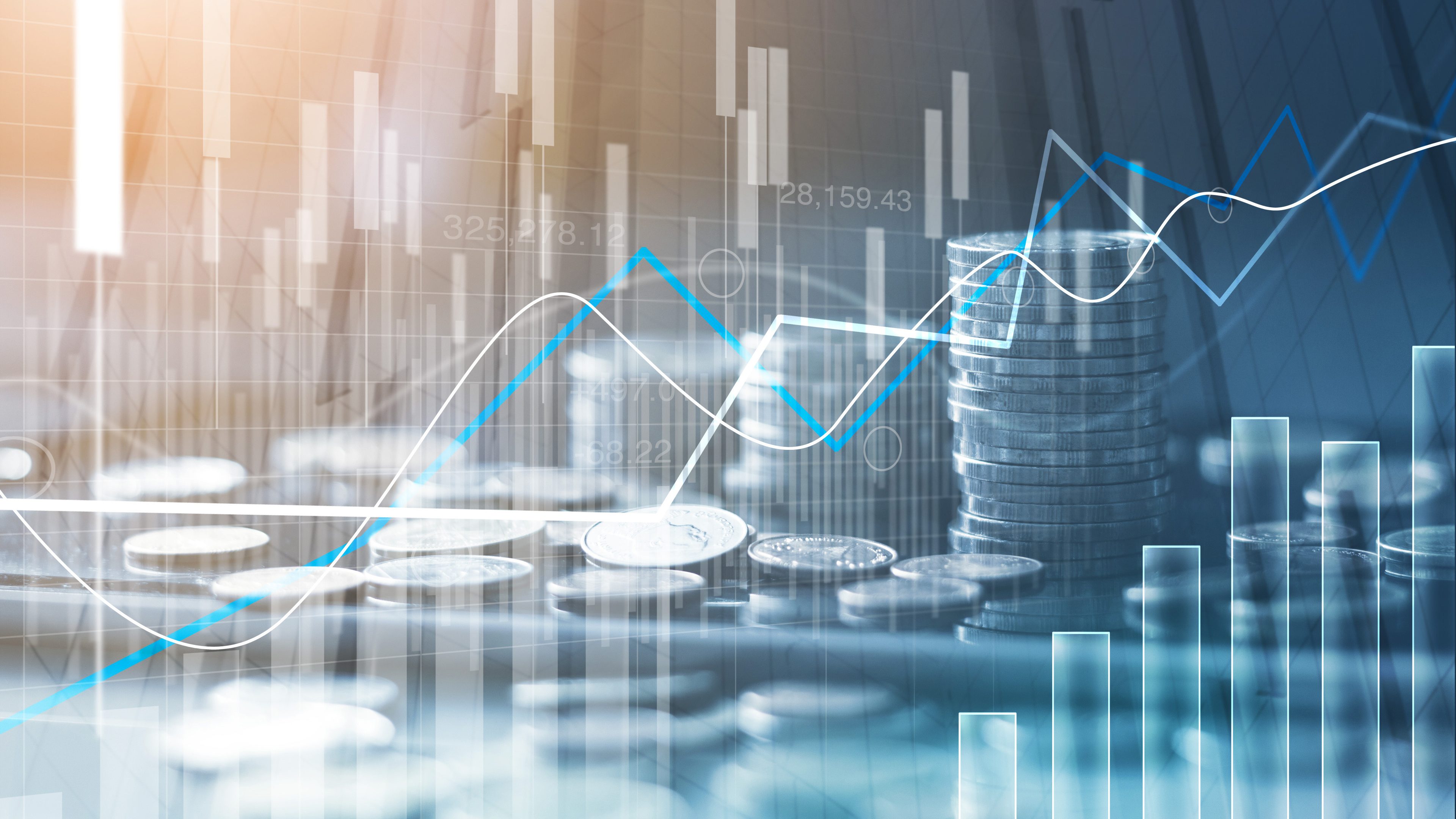 Financial charts flowing up and down and money coins stapled in the background