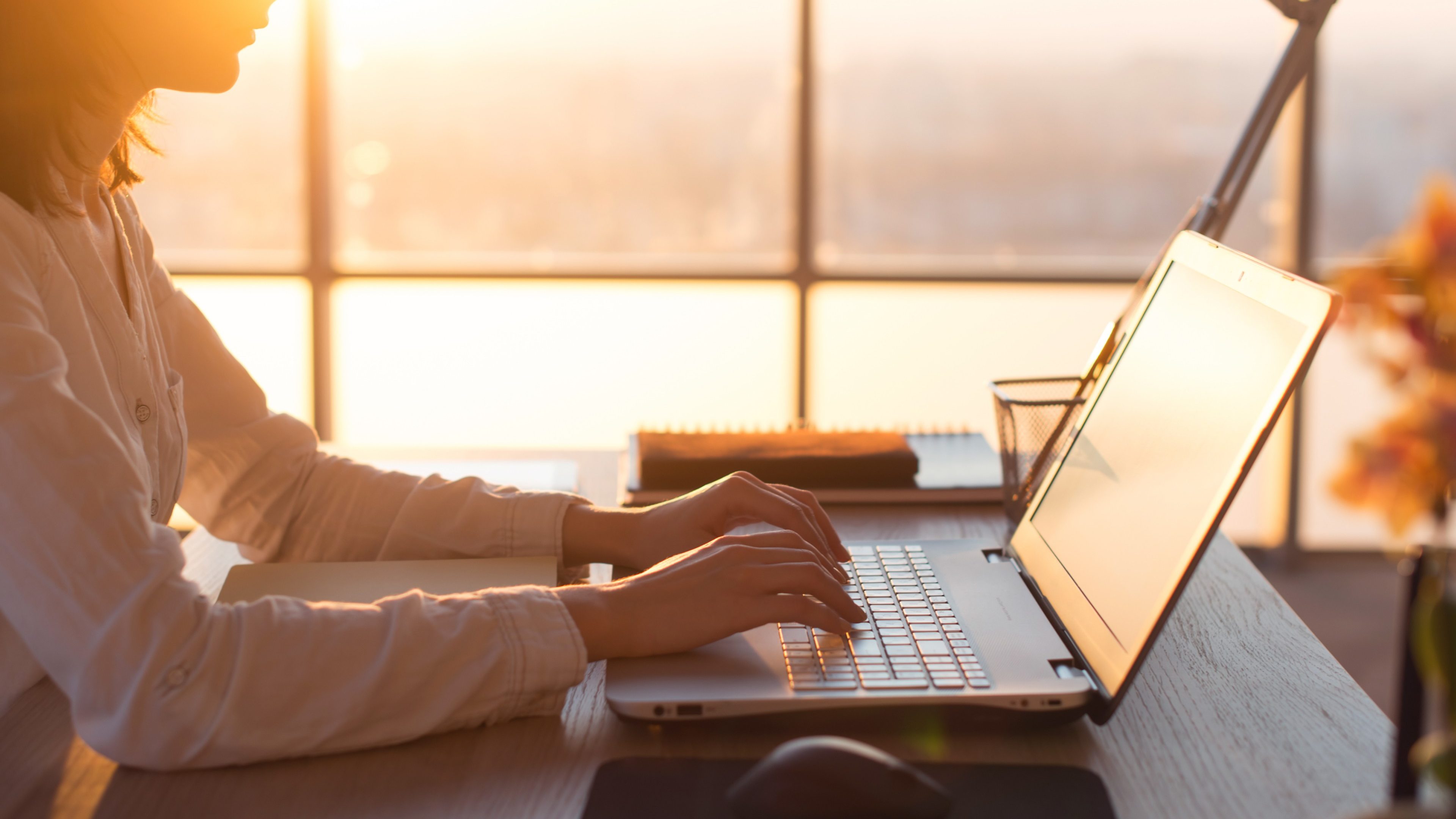 Female teleworker texting using laptop and internet, working online. Freelancer typing at home office, workplace