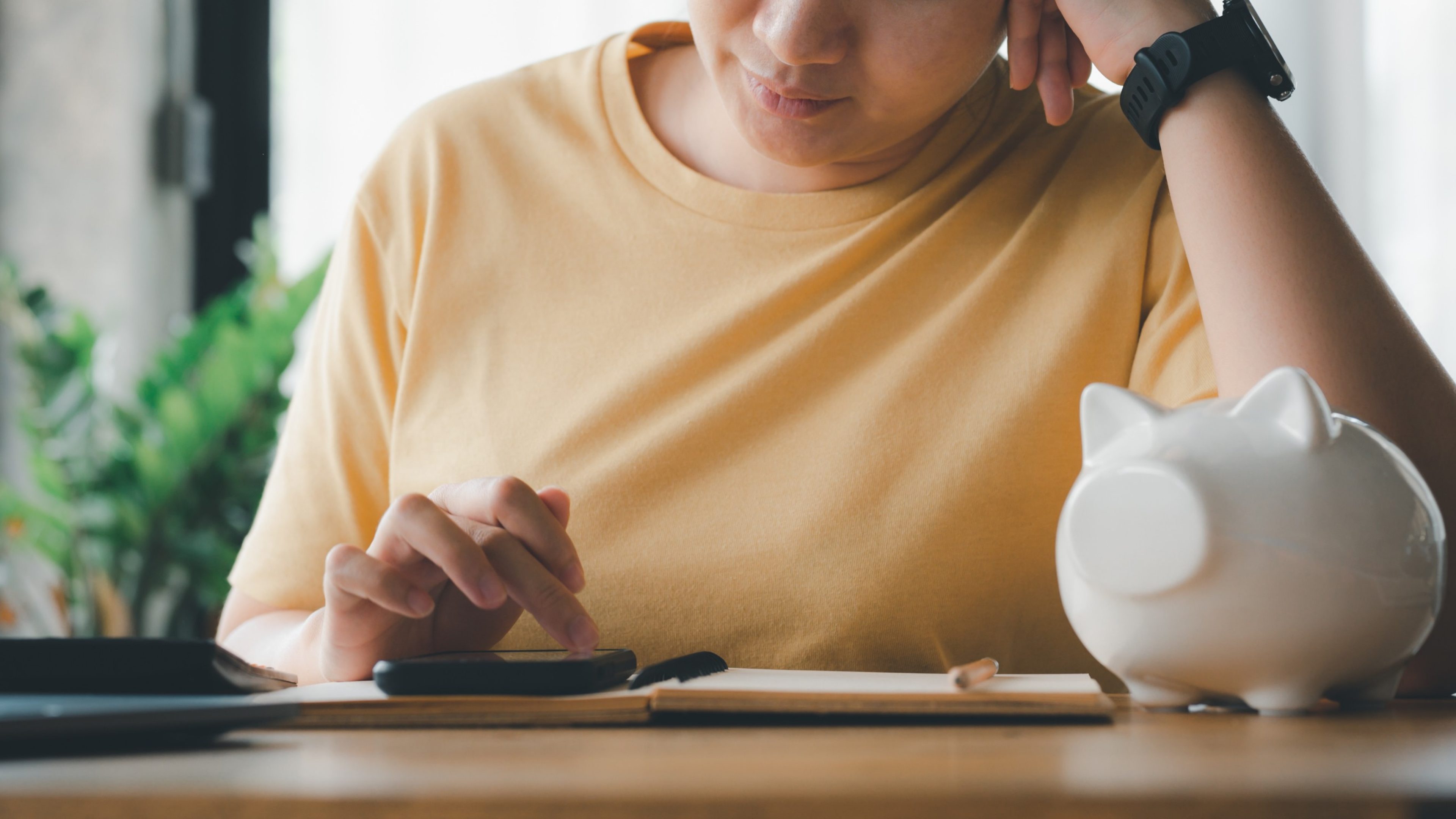 Woman Calculating income and expenses family financial account for step up growing business to profit and saving with piggy bank, Saving money for future plan and retirement fund concept.
