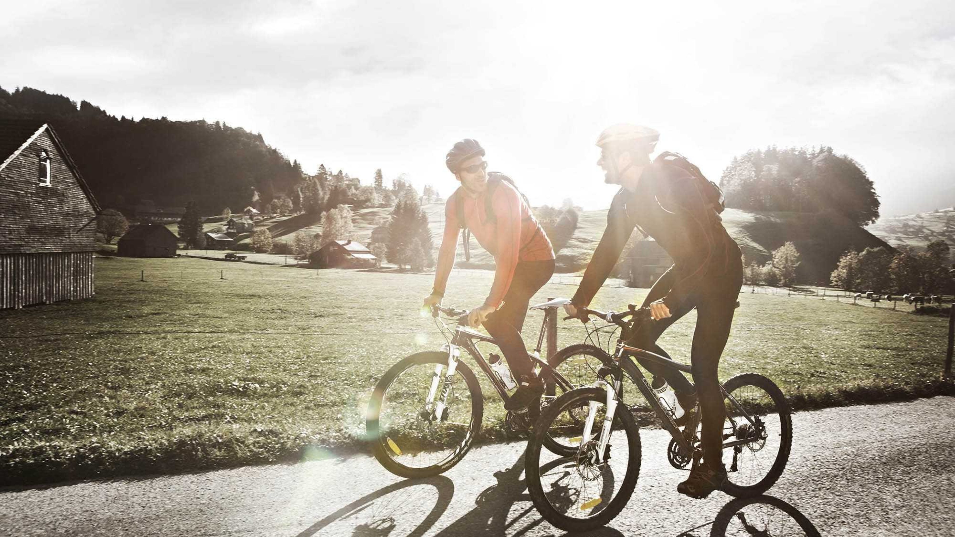 Two men riding bicycles.