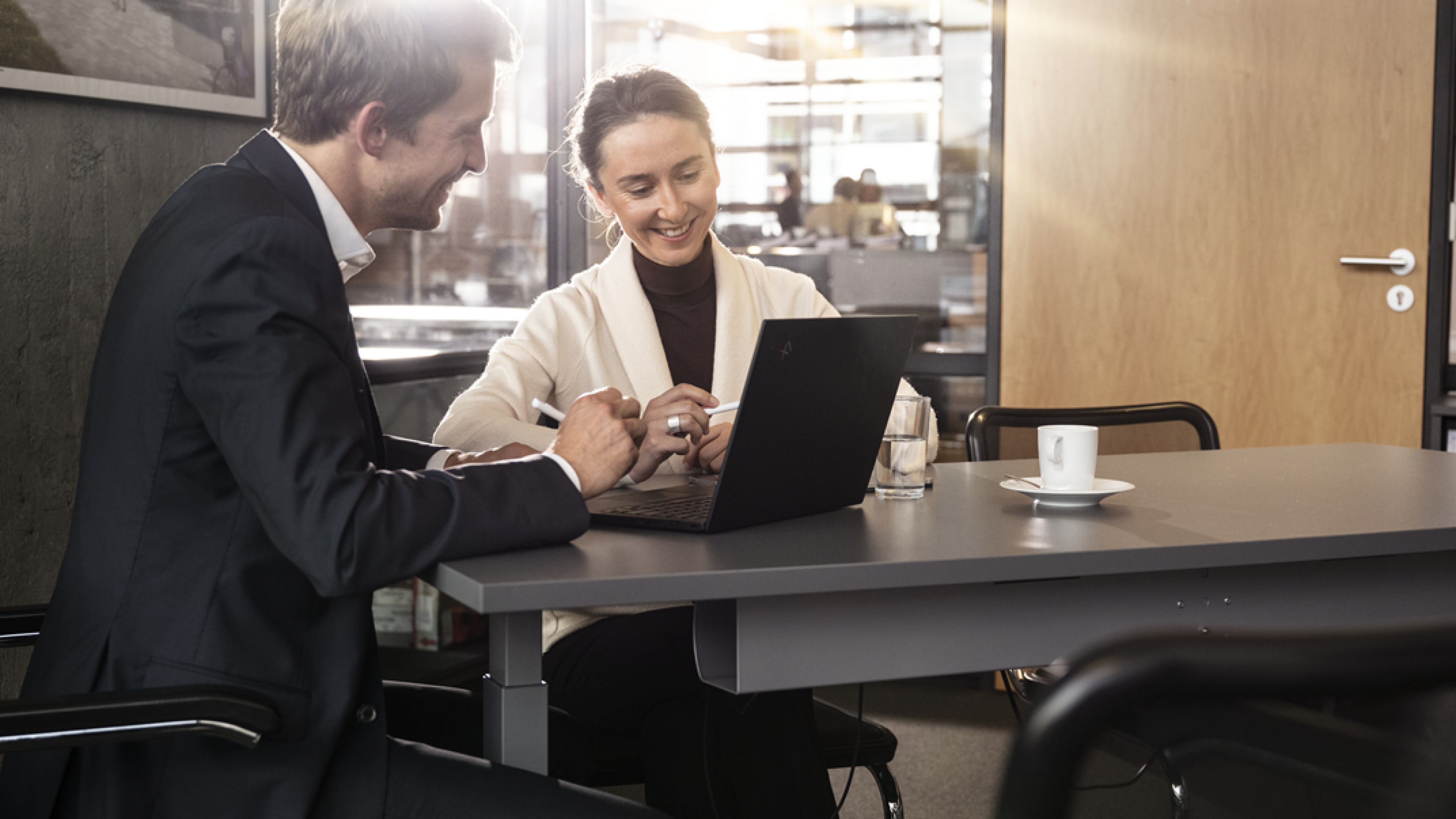 Two people sitting at a laptop talking about funds and investing.