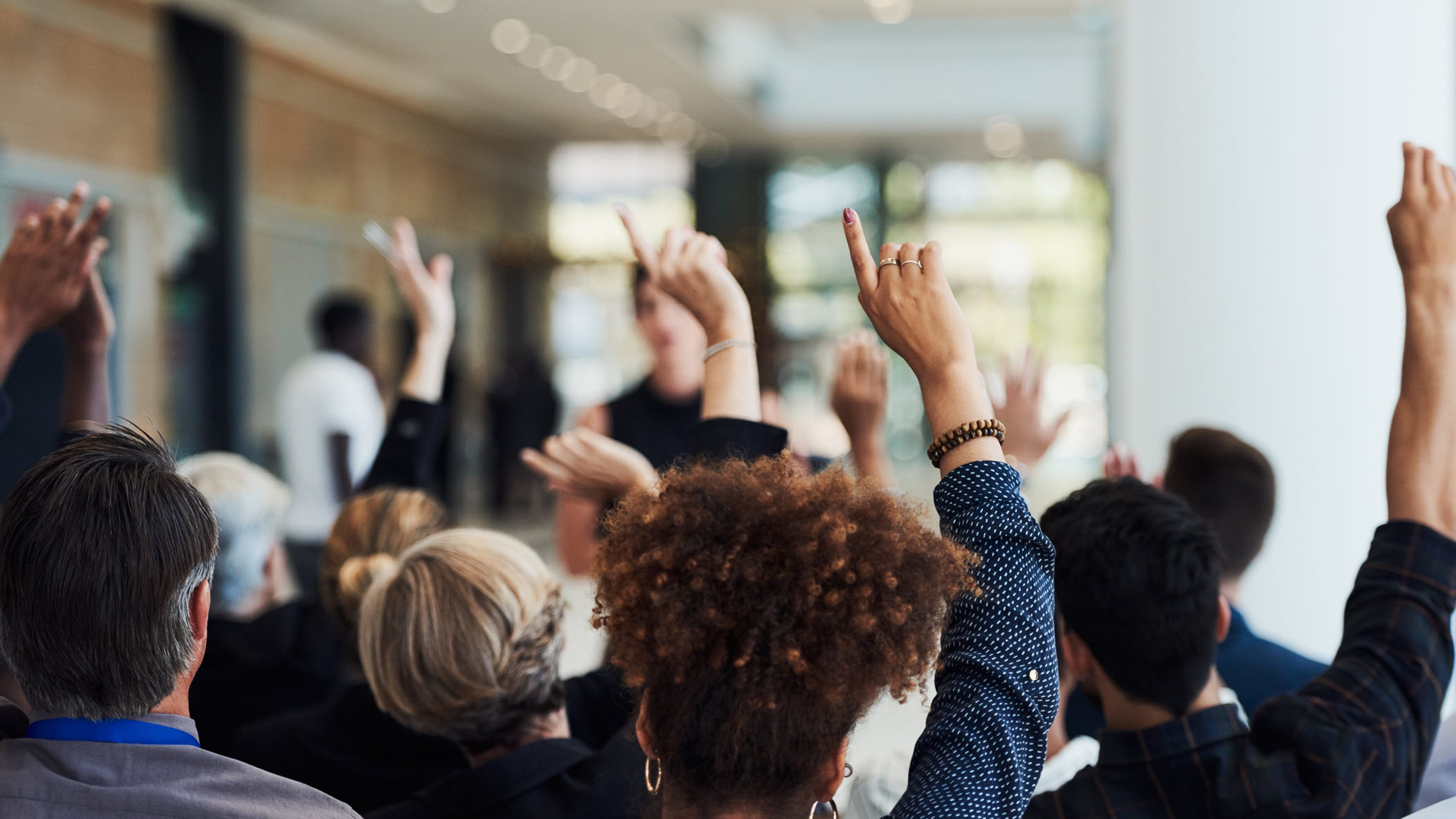 People raising their hands for a vote.