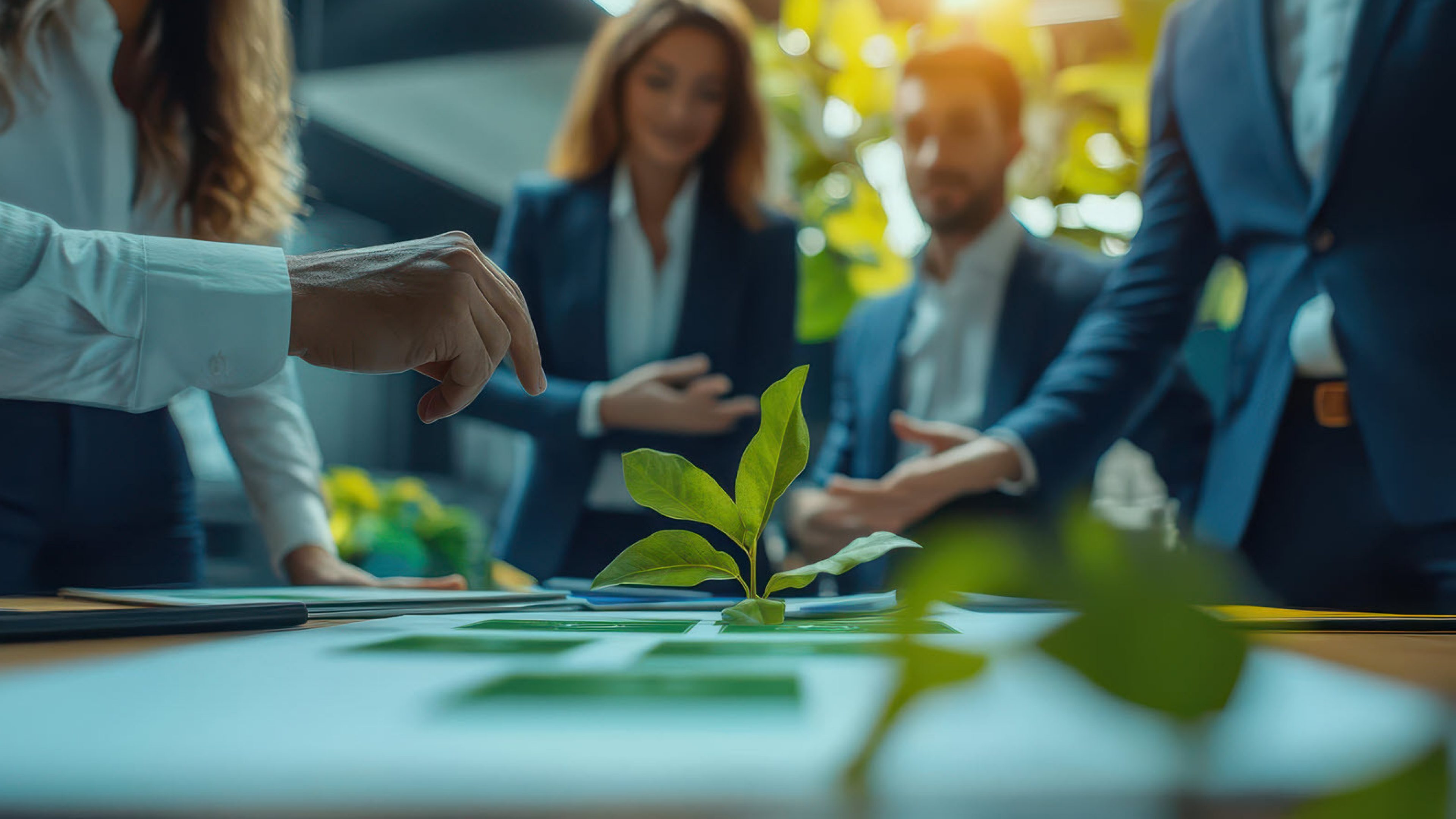 People standing at a table on which there is a plant.