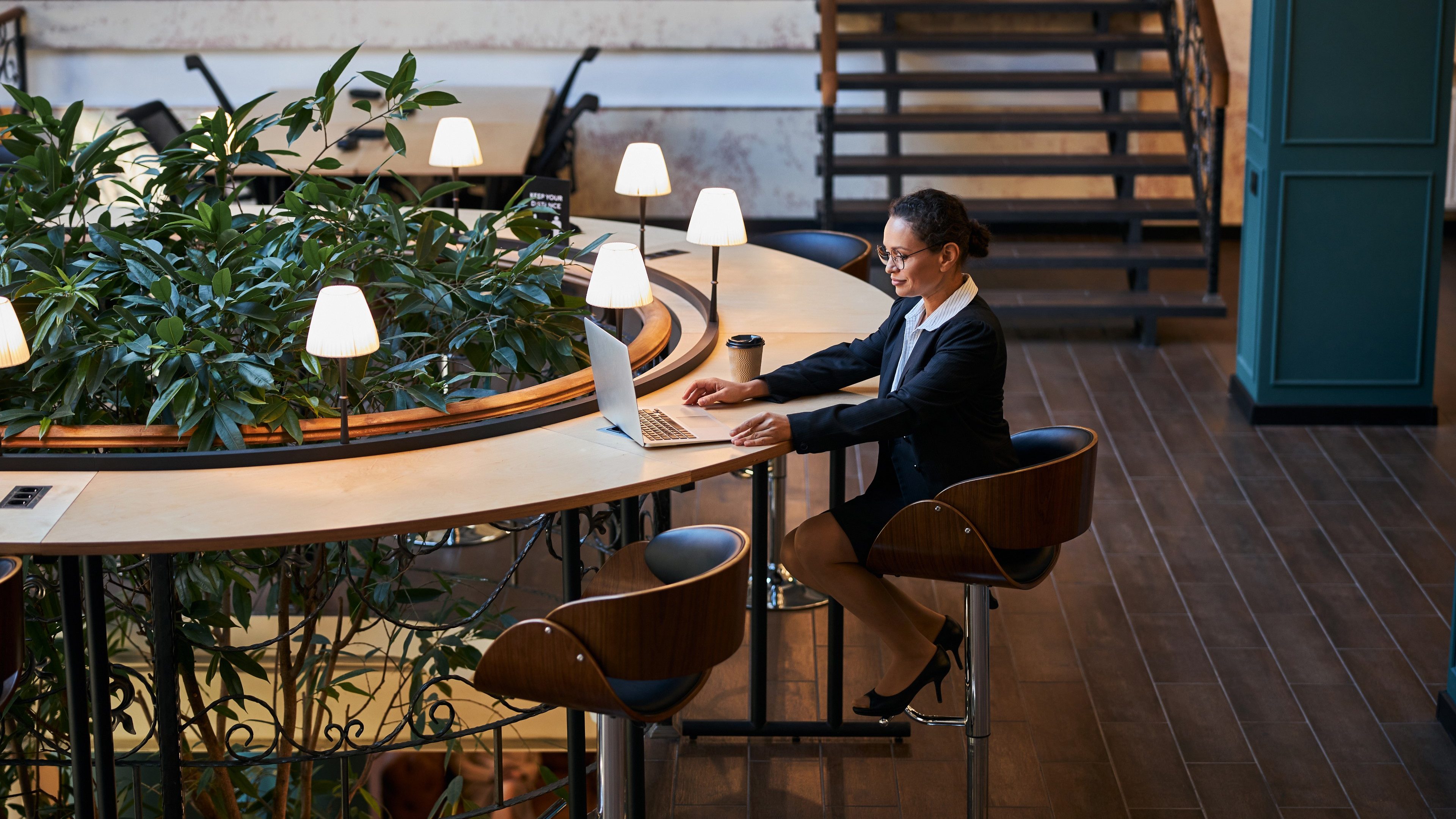 Cheerful international female person staring at her computer while having video conference