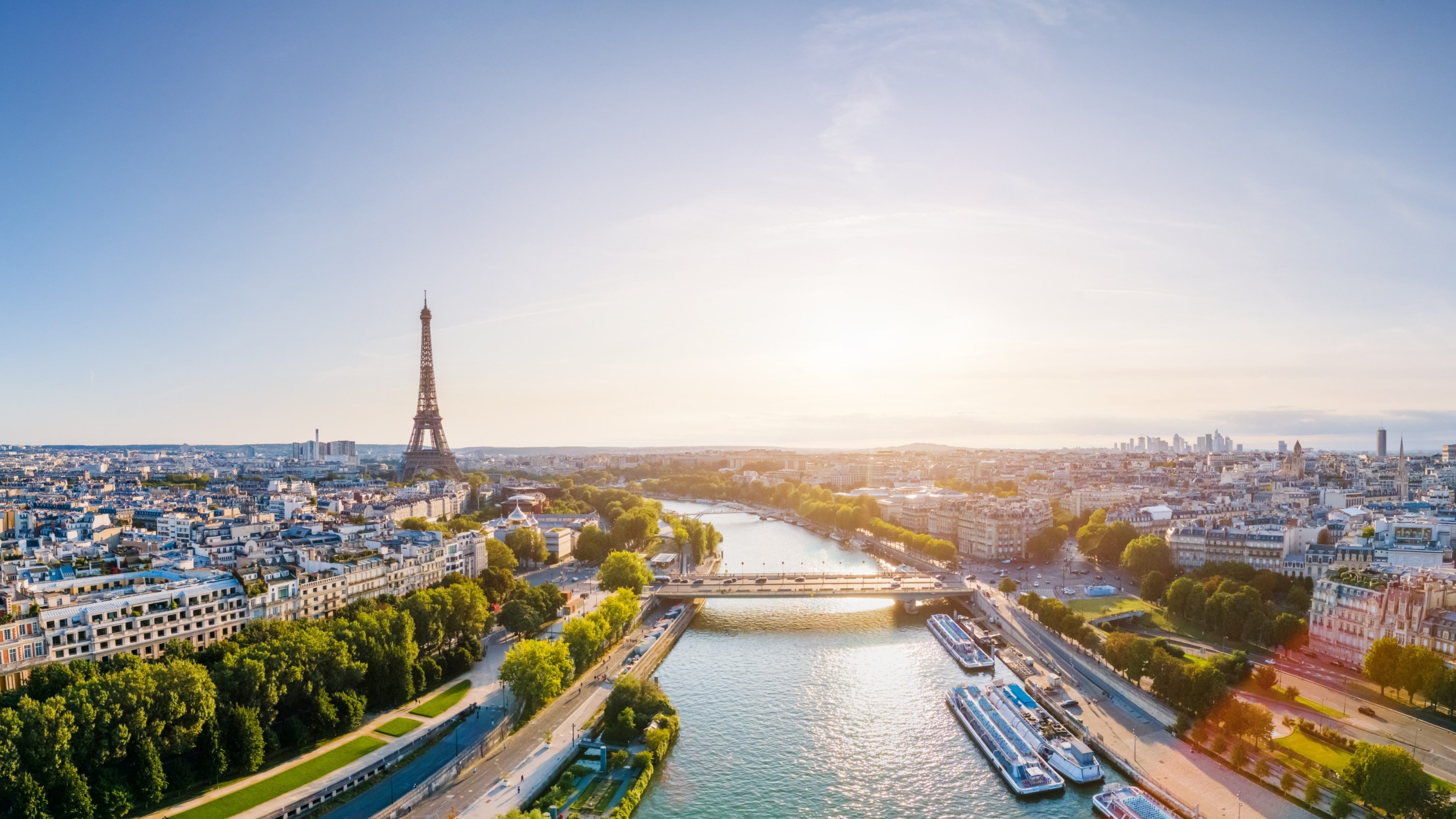 Paris aerial panorama with river Seine and Eiffel tower, France. Romantic summer holidays vacation destination. Panoramic view above historical Parisian buildings and landmarks with blue sky and sun