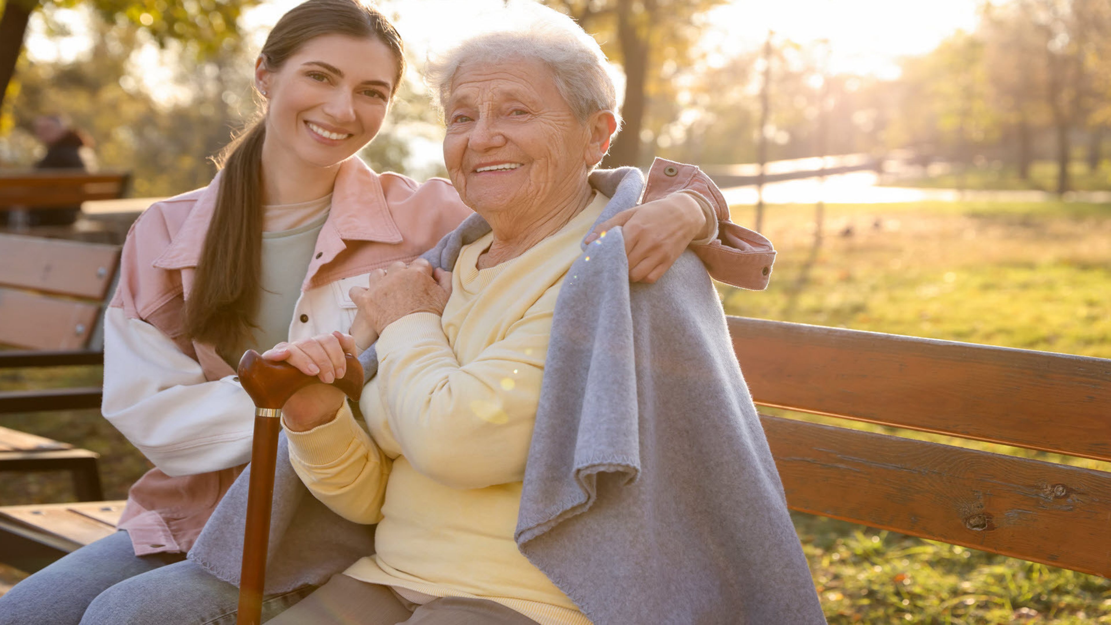 Une femme plus âgée et une femme plus jeune sur un banc de parc.
