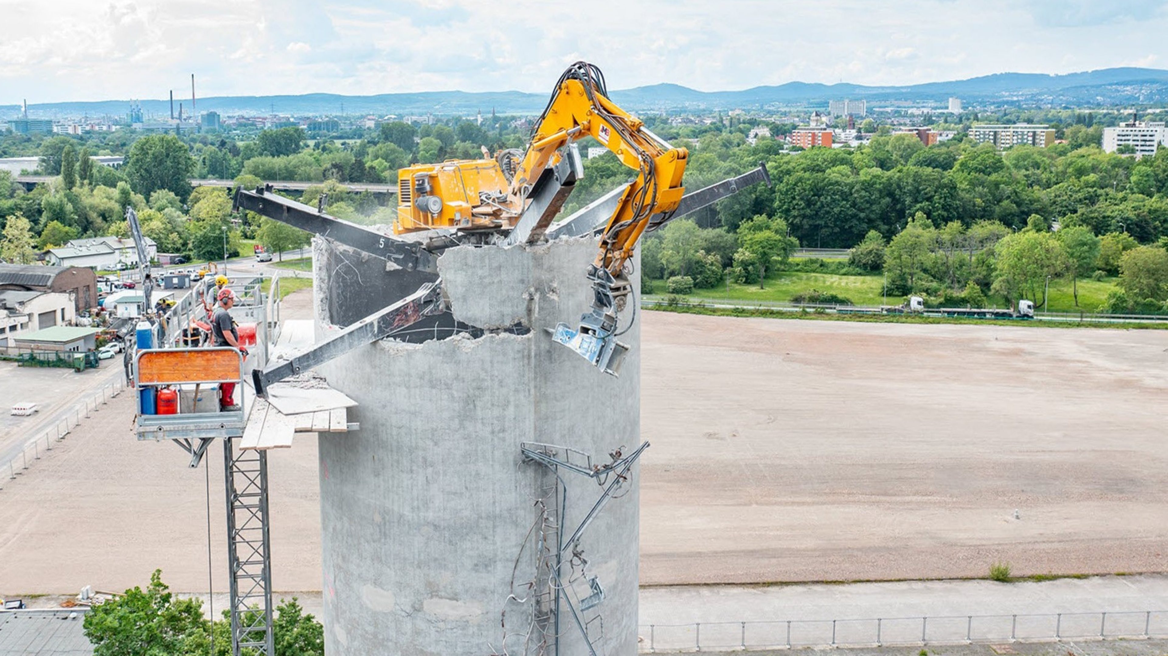 Des images du Frankfurt Westside et d'une pelleteuse en train de démonter une cheminée de 70 mètres de haut.