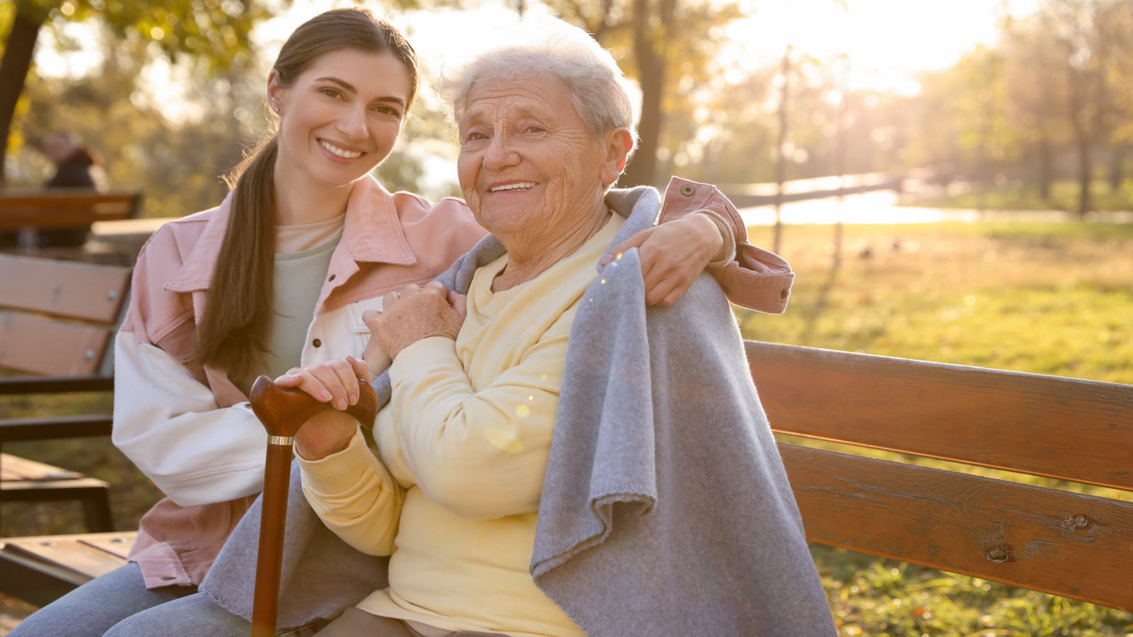 An older and a younger woman on a park bench.